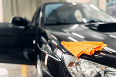 Rag on the hood of clean car on carwash service